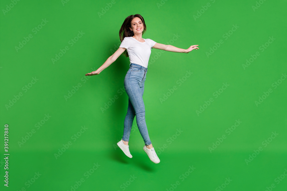 Full length photo of positive girl jump isolated over breen vibrant color background Full length photo of positive girl jump isolated over breen vibrant color background