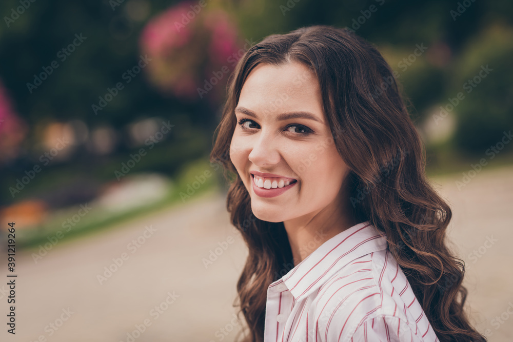 Naklejka premium Photo portrait photo of pretty female student laughing wearing white shirt with red stripes walking in green city park in spring