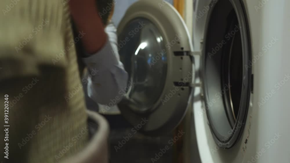 Woman loading clothes into washing machine. Woman loading clothes into washing machine.