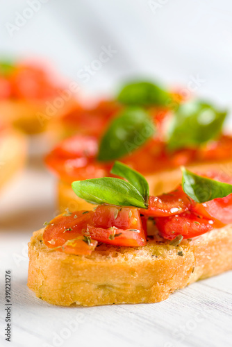 Detail of bruschetta: traditional italian appetizer with tomatoes, basil leaves and olive oil. photo