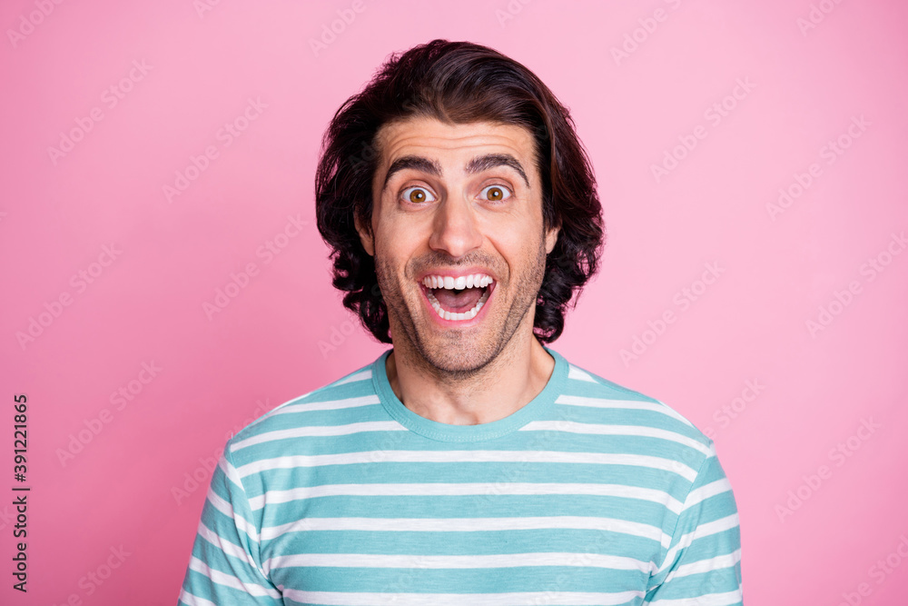 Photo portrait of amazed man smiling with opened mouth wearing blue striped t-shirt staring isolated on pastel pink color background Photo portrait of amazed man smiling with opened mouth wearing blue striped t-shirt staring isolated on pastel pink color background