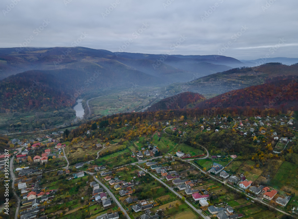 Beautiful morning through mist forest mountain autumn valley village landscape Carpathians Ukraine