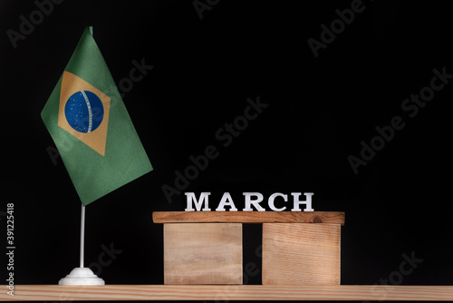 Wooden calendar of March with Brazilian flag on black background. Dates of Brazil in March