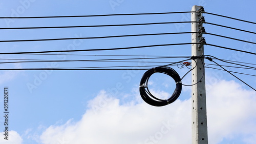 A roll of fiber-optic cables hanging from a pole. Optical fiber cable of high speed internet communication On a blue sky background and copy space. Local focus. Close focus and select an object
