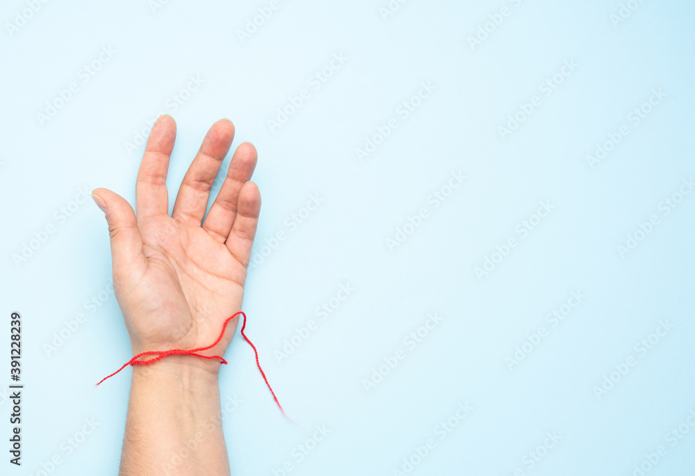 Naklejka premium red woolen thread on the wrist of a female hand