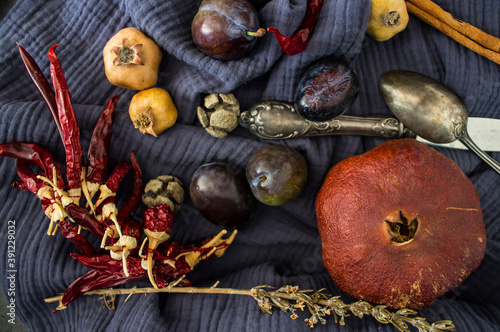 Still life with dried fruits, vegetables and herbs on dark grey textured background. Top view photo of different objects. Colors of autumn.
