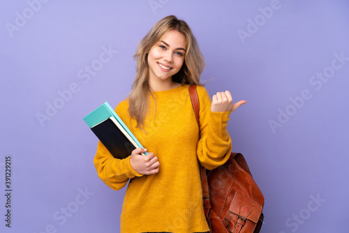 Teenager Russian student girl isolated on purple background with thumbs up gesture and smiling