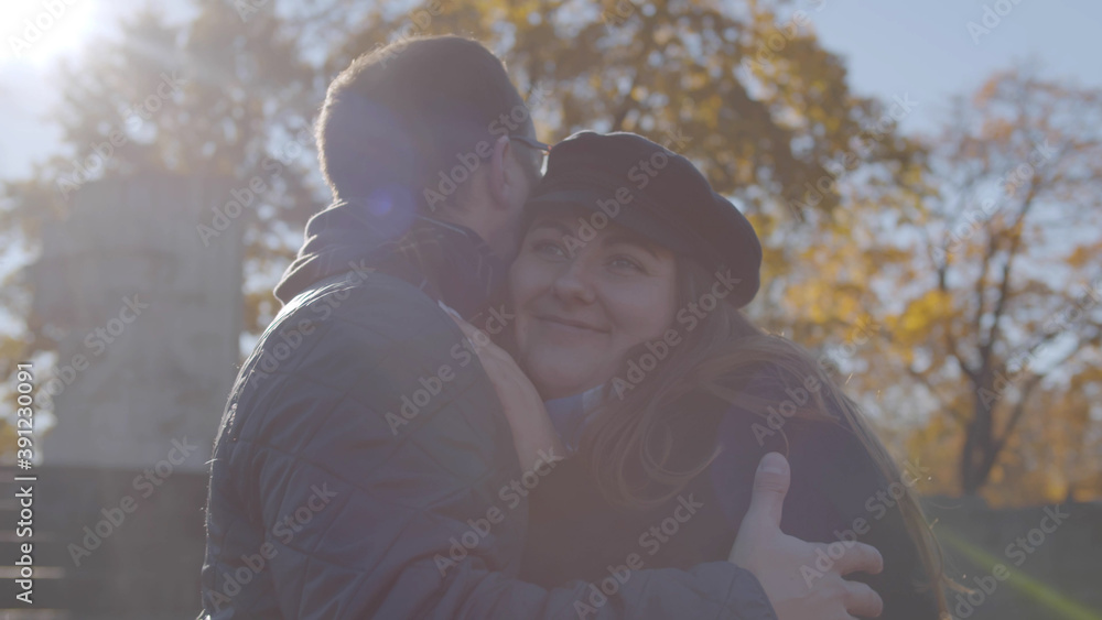 Happy couple in love hug and flirt together in autumn park