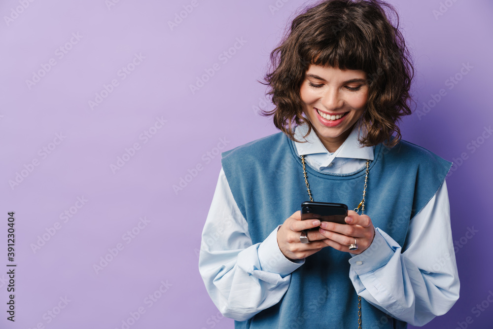 Joyful beautiful girl using smartphone and smiling Joyful beautiful girl using smartphone and smiling
