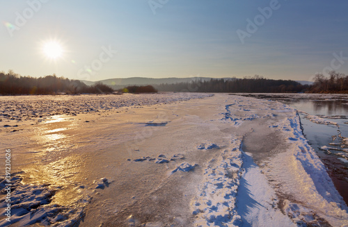 Wallpaper Mural The shore of the freezing river at sunset. Late autumn landscape with an icy and snowy beach. Natural background. Beautiful landscape with the setting sun. Siberian Irkut River Torontodigital.ca