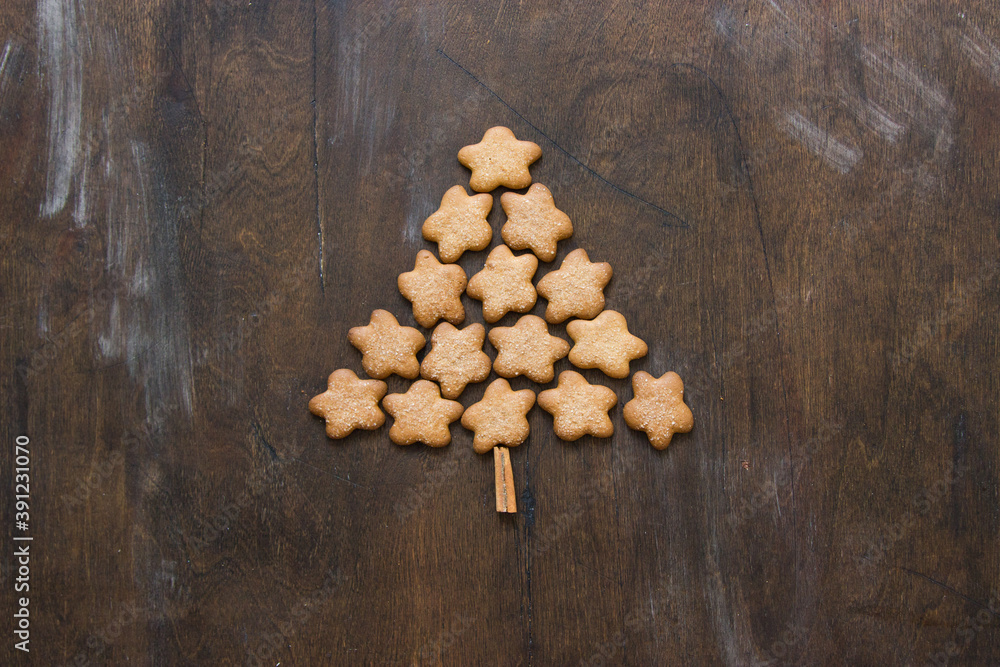 Fototapeta premium Christmas tree made of gingerbreads on a wooden background. Christmas, new year, festive, kids, food concept. free space for text