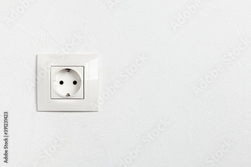 White electric socket on a wall with copy space.