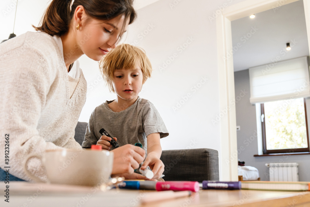 Pretty woman drawing at home with her son Pretty woman drawing at home with her son
