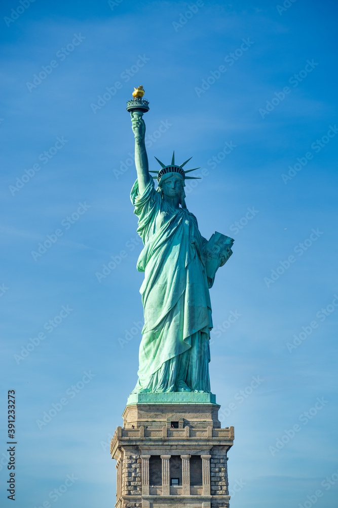 Obraz premium New York City, The Statue of Liberty at sunset with a beautiful colorful sky