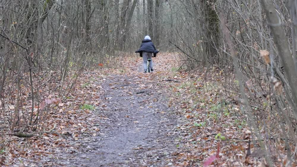 cyclist teenager rides the path in the park in autumn cyclist teenager rides the path in the park in autumn