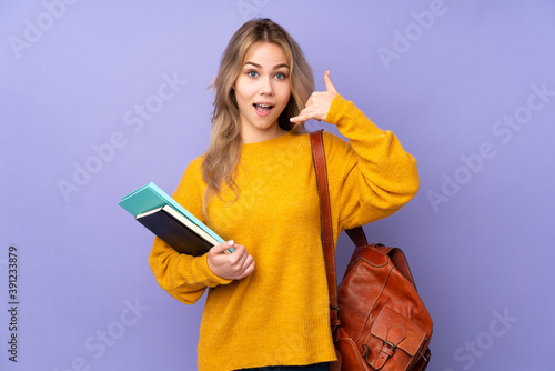 Teenager Russian student girl isolated on purple background making phone gesture. Call me back sign