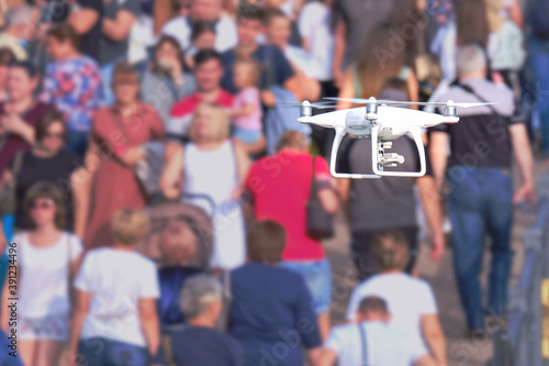 An aerial drone with a camera flies and shoots video over a crowd of people