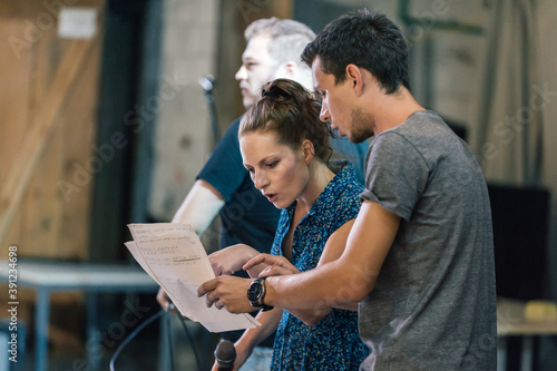 Behind the scene. Director of the play rehearses the play with the actors according to the script photo