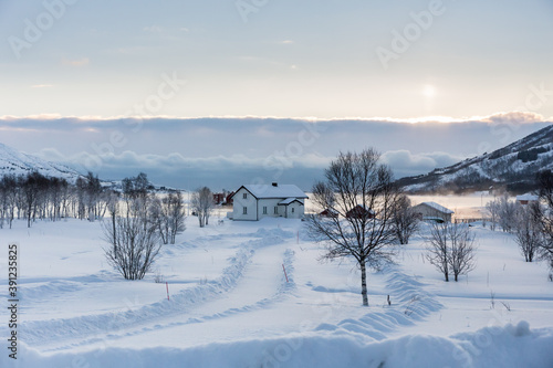 white cabin between snow and small rays of sun