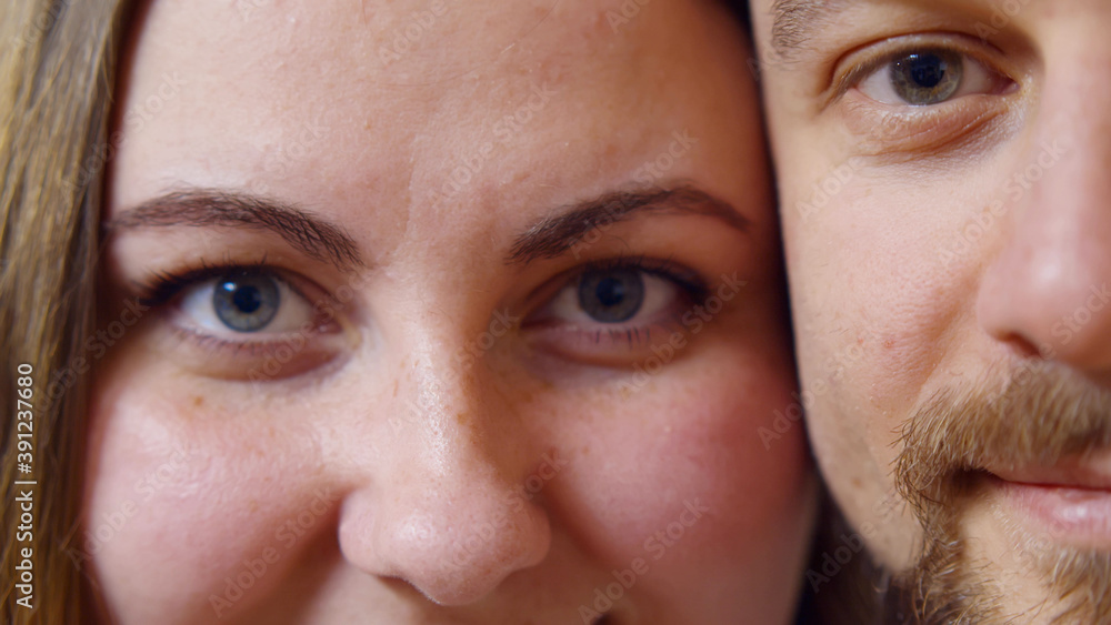 Macro shot of cheerful man and woman looking at camera and smiling Macro shot of cheerful man and woman looking at camera and smiling