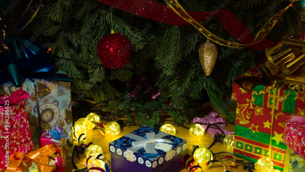 Christmas Surprises for the whole Family. The camera slowly goes down under the decorated Christmas tree under which there are gifts in colorful boxes Christmas Surprises for the whole Family. The camera slowly goes down under the decorated Christmas tree under which there are gifts in colorful boxes