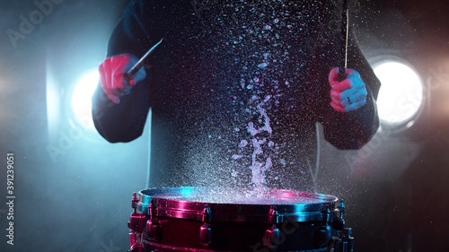 Photographie Freeze motion of drummer hitting drum with water splashes