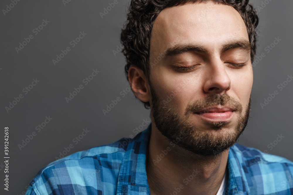 Fototapeta premium Unshaven handsome calm guy posing with eyes closed