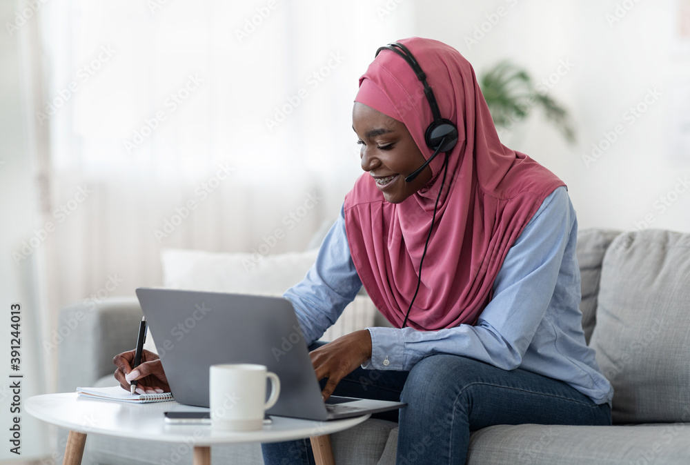 Online Education. Black Muslim Lady In Headset Studying With Laptop At Home Online Education. Black Muslim Lady In Headset Studying With Laptop At Home