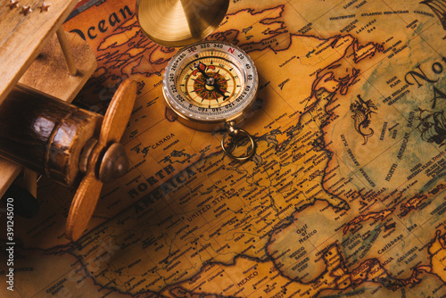 Old compass discovery and wooden plane on vintage paper antique world map background, Retro style cartography travel geography navigation, Columbus Day concept