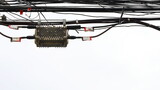 Metal boxes hanging on the wires. Fiber Optic Splitter Box (Plc / Coupler) is an optical splitter for fiber optic cables of high speed internet. On a white background with a copy area. Selective focus