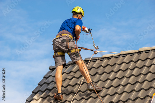  high-altitude worker painting a roof