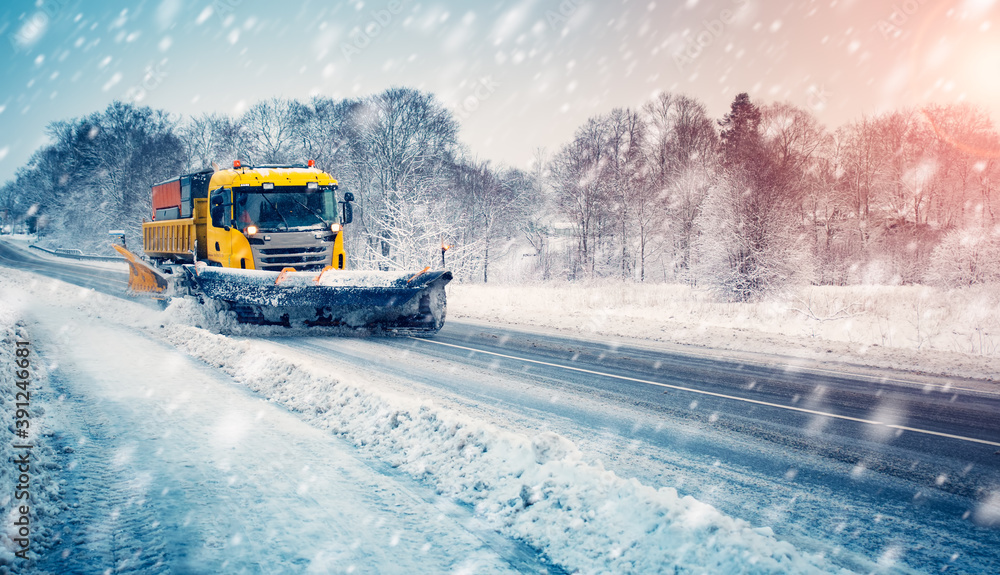 Snow plow truck cleaning snowy road in snowstorm Snow plow truck cleaning snowy road in snowstorm