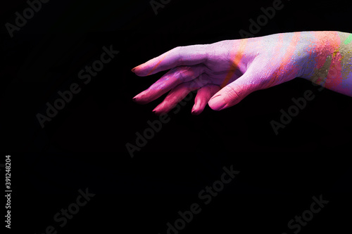 A beautiful female multicoloured hand wants to take something on a black isolated background, banner concept art 