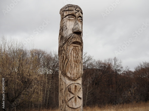 ancient wooden idol of the Slavic Scandinavian god against the sky © Yulia