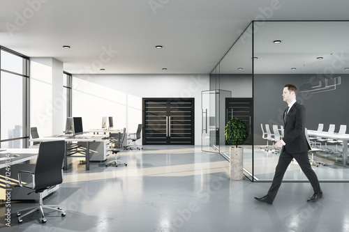 Businessman walking in conference interior with negotiation table