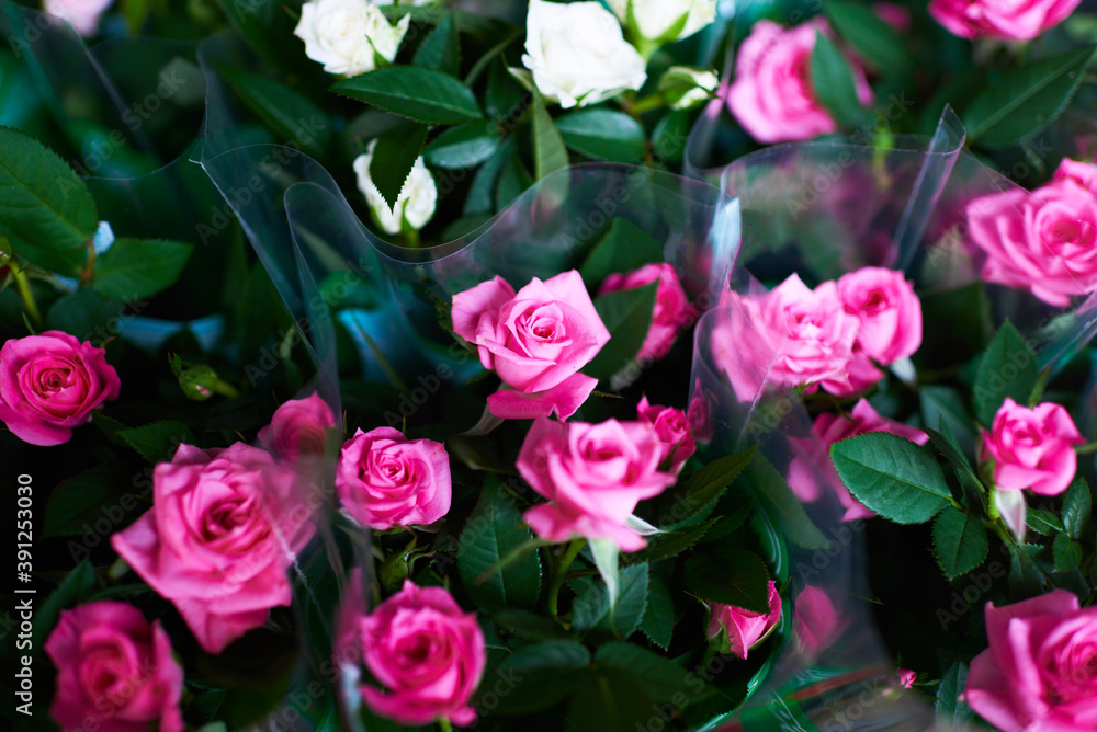 Fototapeta premium Beautiful bouquets of pink roses in a flower shop. A bright mix of flowers. Handsome fresh bouquets. Flowers delivery. Floral shop concept .