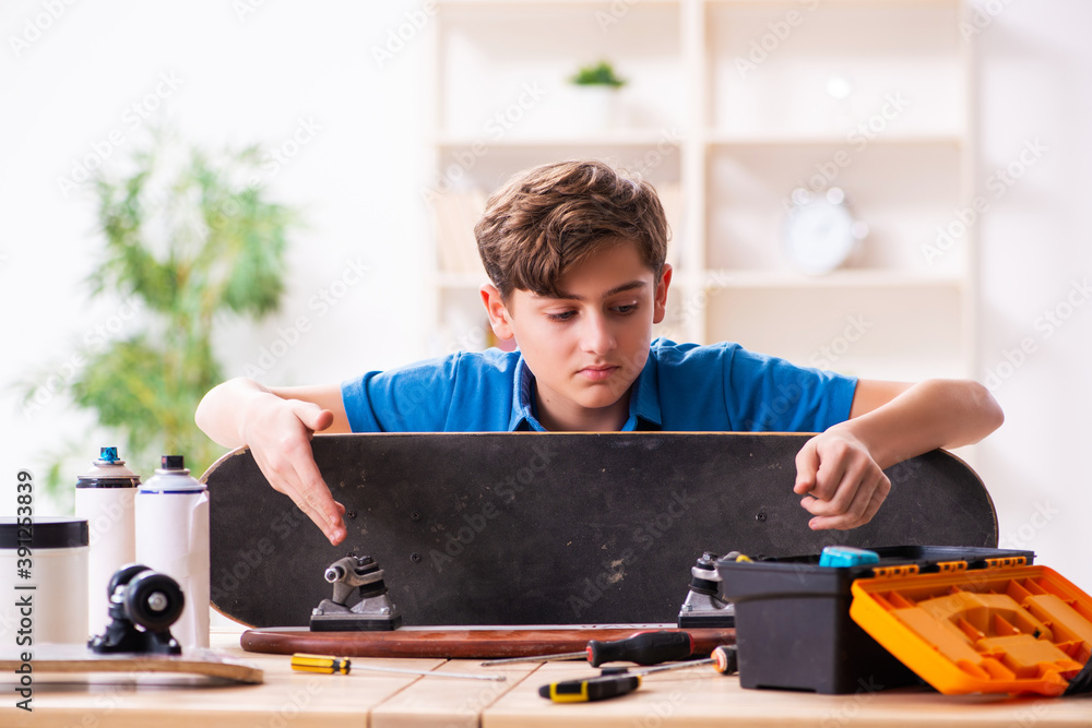 Boy reparing skateboard at home Boy reparing skateboard at home
