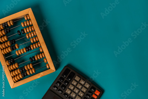 Foto Top view of vintage abacus and modern calculator on a green background, the conc