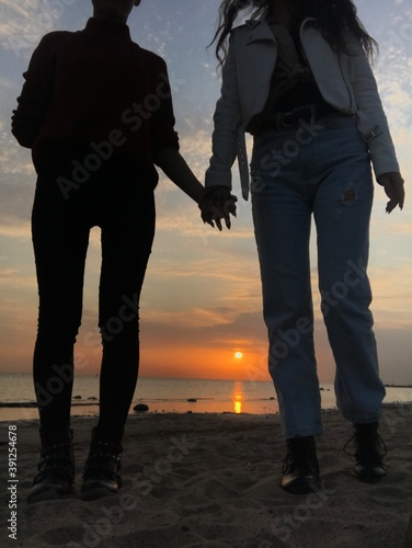 couple walking on the beach at sunset