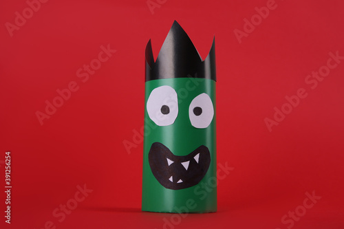 Funny green monster on red background. Halloween decoration