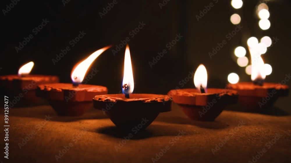 Diwali Diya oil lamp lit during diwali festival in India with bokeh lights isolated in black background. Stock footage for diwali, temple, religious. with copy space Diwali Diya oil lamp lit during diwali festival in India with bokeh lights isolated in black background. Stock footage for diwali, temple, religious. with copy space