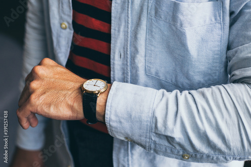 fashionable wearing stylish looking at luxury watch on hand check the time at workplace.concept for managing time organization working punctuality appointment