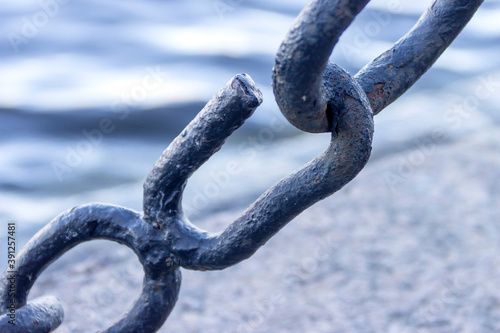 The broken link of an old rusty nautical chain.