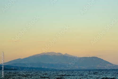 Dark blue and yellow background with mountains and sea