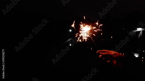 Slow video clip of a yellow scab splashing from fireworks in hand  and  black background.