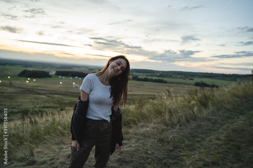 Happy woman tourist climbs mountain shihan in steppe, green dry grass Happy woman tourist climbs mountain shihan in steppe, green dry grass