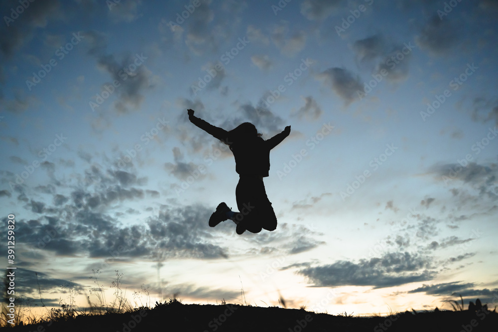 silhouette of a girl jumping against a sunset background,