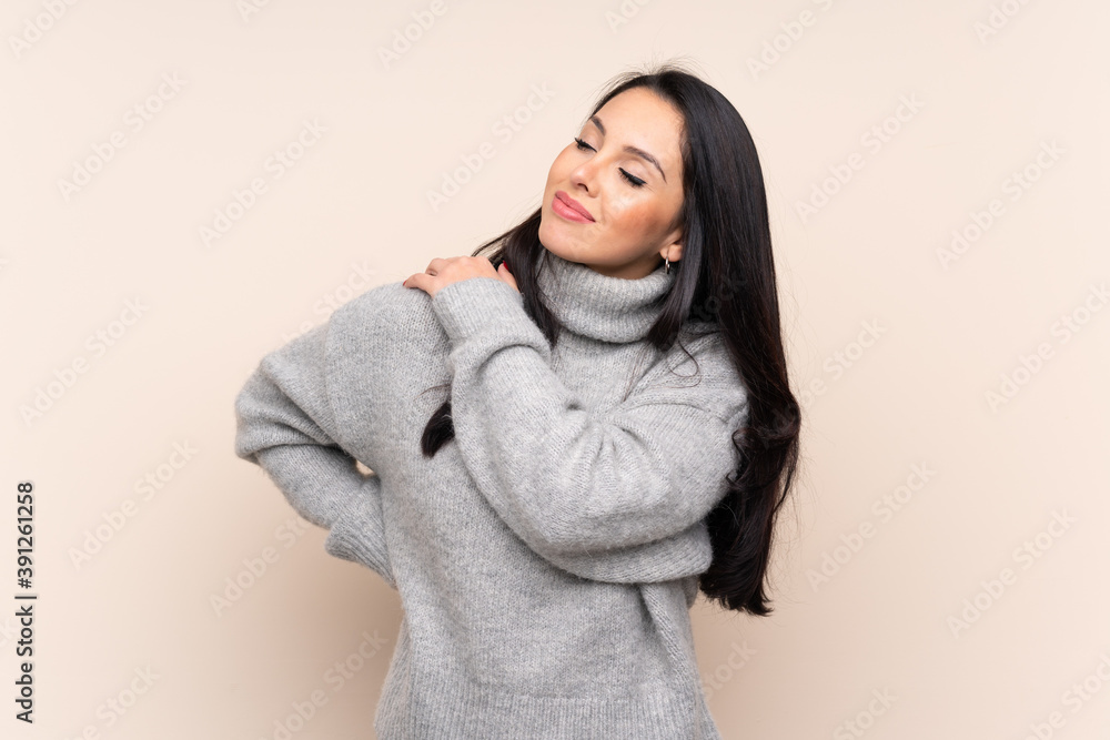 Young Colombian girl over isolated background suffering from pain in shoulder for having made an effort Young Colombian girl over isolated background suffering from pain in shoulder for having made an effort