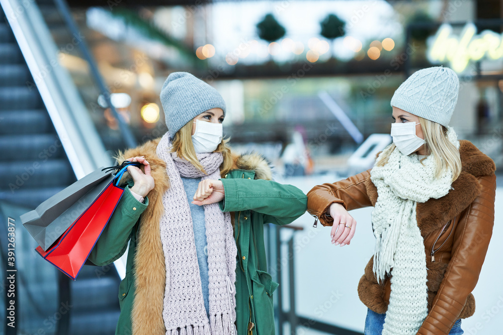 Portrait of two friends shopping together wearing a mask, coronavirus concept