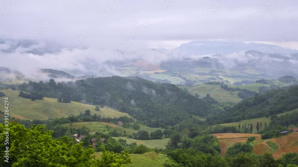 Timelapse of wind blowing rain storm clouds over green fields and hills in Italy, summer nature outdoor landscape panorama view. Green and yellow grass, natural scenery. High quality 4k footage Timelapse of wind blowing rain storm clouds over green fields and hills in Italy, summer nature outdoor landscape panorama view. Green and yellow grass, natural scenery. High quality 4k footage